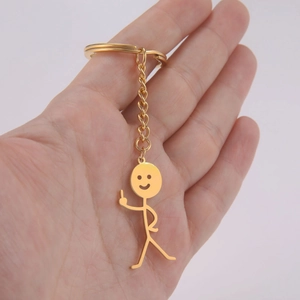 Detailed view of a gold funny stickman keychain with an offensive finger gesture