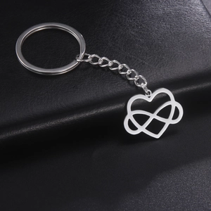 Silver infinity heart pendant keychain on black leather background for couples