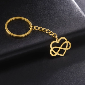 Close-up of golden stainless steel keychain with heart and infinity symbol on black leather