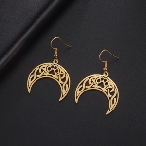 Detailed close-up of golden crescent moon earrings with celtic knots and cat paw cutouts