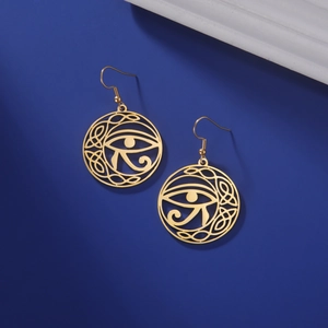 Macro detail of gold Eye of Horus and Celtic knot hollowed-out vintage steel earrings