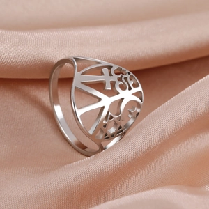 Close-up of stainless steel ring with cutout peace, cross, and crescent star symbols