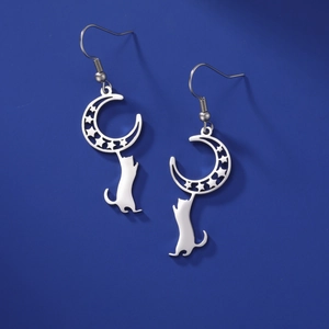 Macro shot of silver crescent moon and playful cat silhouette drop earrings