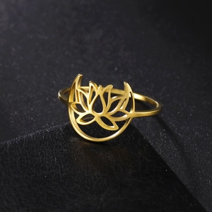 Detail of gold lotus and crescent moon cutout ring on black jewelry display