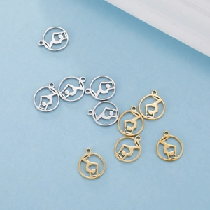 Macro view of gold and silver cutout pendants with yoga figures for DIY jewelry