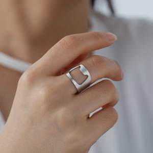 Macro shot of silver stainless steel bottle opener ring showing functional hollow design