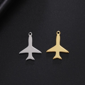 Colgantes de avión pulidos en oro y plata para bisutería DIY sobre fondo negro