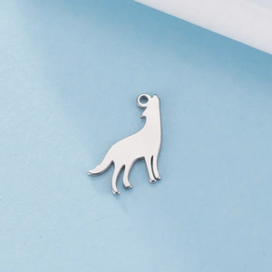 Detalle del colgante con silueta de lobo aullando en acero inoxidable pulido brillante