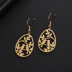 Vue détaillée de boucles d'oreilles oiseaux dorés sur un fond noir élégant