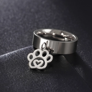 Macro van brede roestvrijstalen ring met bungelende kattenpoot-hanger en hartje