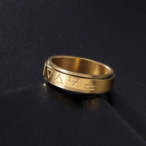 Gold wide spinning ring with engraved geometric triangle patterns on brushed steel