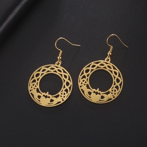 Detail van gouden Claddagh-oorbellen met Keltische knopen op zwart leer decor