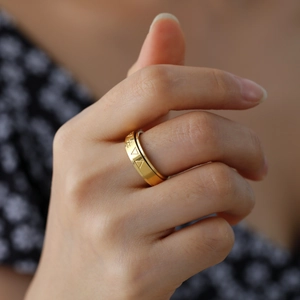 Polished gold rotatable triangle pattern stainless steel ring on model's finger