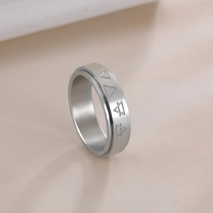 Macro detail of rotating stainless steel ring with engraved triangle geometric patterns