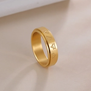 Detail view of gold stainless steel rotating ring with engraved triangle symbols