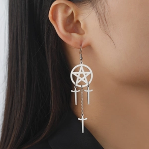 Gros plan de boucles d'oreilles pentagramme avec croix pendantes et glands longs