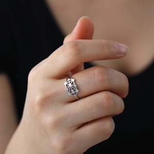 Macro d'une bague ajustable en acier inoxydable argenté avec motif étoile géométrique
