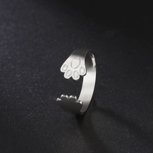 Macro view of adjustable stainless steel ring featuring a cute polished dog paw design