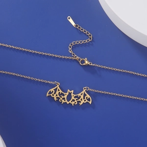 Detailed view of the gold hollow-out bat pendant with intricate filigree and clasp