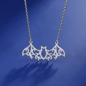 Gothic hollow bat pendant necklace in silver stainless steel on a blue background