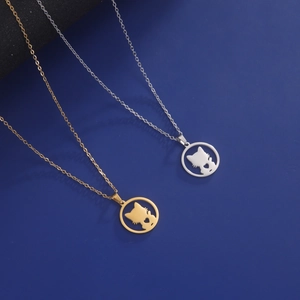 Minimalist cat and heart pendant necklace in gold and silver finish on blue background