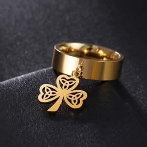 Polished gold stainless steel wide ring featuring a Celtic knot clover leaf pendant detail