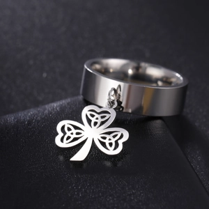 Polished stainless steel band ring featuring a hanging Celtic knot shamrock charm