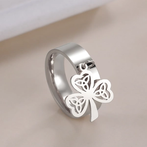 Polished stainless steel wide band ring with a dangling Celtic knot clover charm
