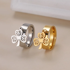 Detailed view of silver and gold stainless steel rings with Celtic clover pendants