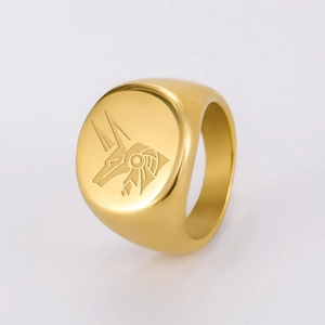 Dettaglio macro dell'anello a sigillo in acciaio dorato con motivo egizio di Anubi