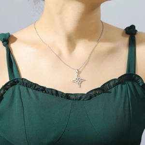 Détail d'un collier pendentif nœud celtique argenté porté par un mannequin femme