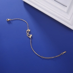 Detailed macro view of 18K gold-plated baby footprint charms on an adjustable link chain