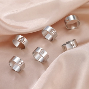 Set of six silver open rings featuring cutout zodiac signs on champagne silk