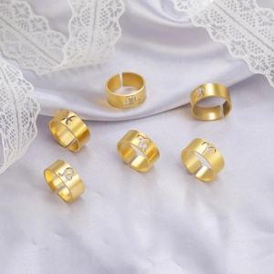Set of 6 adjustable hollow 18k gold plated stainless steel zodiac rings on purple silk