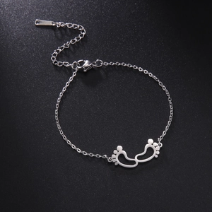 Polished stainless steel bracelet with hollow baby footprint charms and lobster clasp
