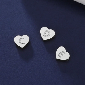 Détail macro de pendentifs en forme de cœur en acier inoxydable avec lettres gravées