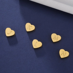 Détail macro de pendentifs cœur en plaqué or 18K avec lettres pour bijoux DIY