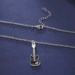 Detailed close-up of a silver electric guitar pendant with black enamel and rhinestones