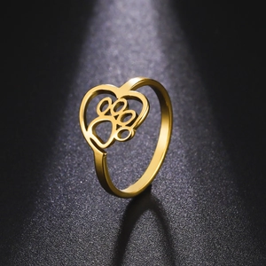 Golden stainless steel heart ring with hollow pet paw print design on black background