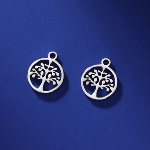 Macro shot of silver tree of life pendants with hollow design for DIY jewelry