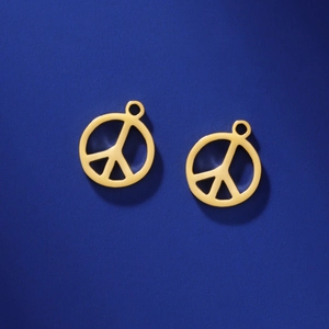 Detailed view of two gold stainless steel peace sign pendants on navy blue background