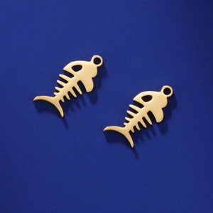 Pair of polished gold stainless steel fishbone pendants on a deep blue textured surface
