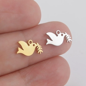 Polished stainless steel peace dove pendants in gold and silver held by fingers
