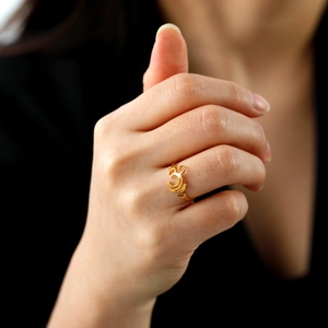 Minimalistischer goldener Edelstahlring mit Om-Symbol, präsentiert an der Hand am Model