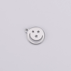Détail macro d'un pendentif argenté évidé avec visage souriant et étoiles pour bijoux