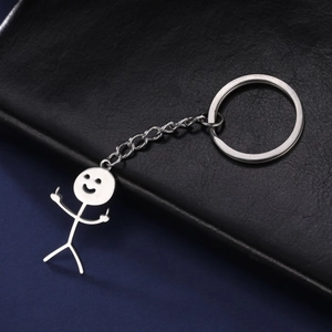 Macro detail of silver stainless steel funny doodle keychain on black leather surface