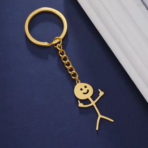 Detailed view of a gold smiley stickman keychain with funny middle finger gesture
