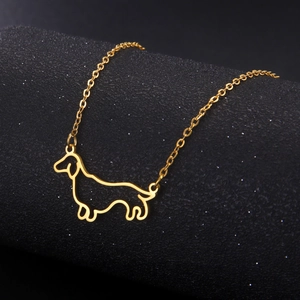 Detail of a gold dachshund pendant on an O-chain against a textured black background