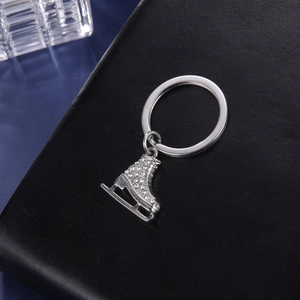 Vue détaillée du porte-clés patin à glace avec strass brillants sur fond de cuir noir