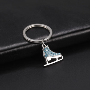 Porte-clés patin à glace avec strass bleus et anneau argenté sur cuir noir élégant